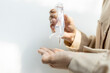 © Satjawat - Hands of girl squeezing the hand sanitizer on her palm or pour skin care lotion from small portable plastic bottle,female people washing hand with alcohol antiseptic gel,cleaning,health and safety