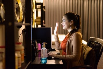 Portrait of happy young beautiful Indian woman video calling and working from home late at night