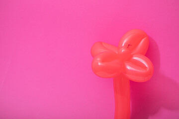 Balloons shaped in the form of a flower over a pink background. Beautiful artificial flower made with balloons. Hand made birthday object.