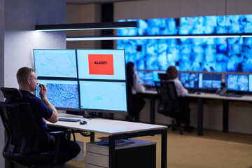 young male operator working in a security data system control room