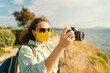 © olezzo - Cool beautiful happy girl woman traveler by the sea with a mask on her face, stylish outfit, with a camera in her hands