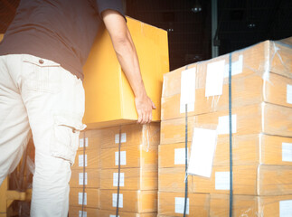 Wall Mural - Warehouse worker lifting shipment boxes, cartons, cardboard box, warehouse delivery service shipping goods at manufacturing warehouse.