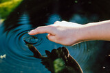 Fototapeta Lawenda - Index finger taps on water
