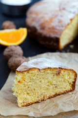 orange and walnut cake on black background.