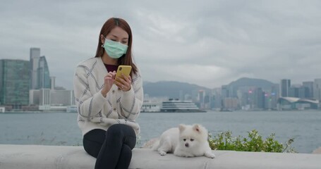 Canvas Print - Woman wear face mask and use of mobile phone with her dog