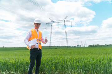 Engineer working near transmission lines. Electrical engineer checks high voltage lines. Transmission towers. Energy efficiency conception