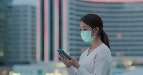 Wall Mural - Woman wear face mask and use of mobile phone at night