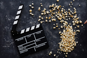 Filmmaking concept. Movie Clapperboard. Cinema begins with movie clappers. Movie clapper on a dark background and a scattering of popcorn.