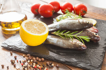 fish with a lemon and tomatoes on a table, selective focus