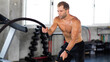 © NVB Stocker - Fitness and sports man training with battle rope in cross fit gym. Fitness Healthy lifestye and workout at gym concept.