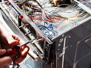 repairman mounts old electric stove during repair in home kitchen