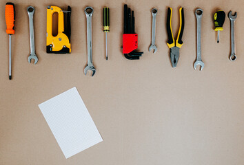 Wall Mural - Tools top view on craft paper. Plier, open wrenches and screwdrivers flat lay with copy space. Tools and white piece of paper.