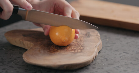 man cut fresh orange lemon on olive board