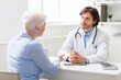 © Prostock-studio - Attentive doctor listening to senior patient at his office
