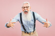 © Alessandro Biascioli - Senior man having fun posing in front camera - Happy mature male enjoying retired time - Elderly people lifestyle and hipster culture concept - Pink background