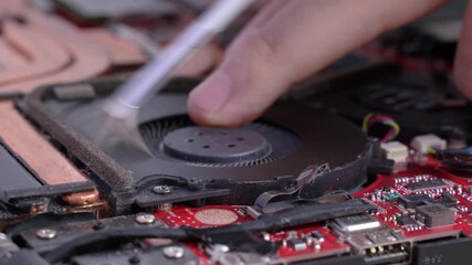 Canvas Print - man cleans a laptop with a brush for blowing dust cooling system. Repair and service laptops and PC Advertisement of repair service for electronics and devices