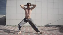 A Man Plays Sports On The Roof. A Complex Set Of Exercises Based On Gymnastics And Karate.