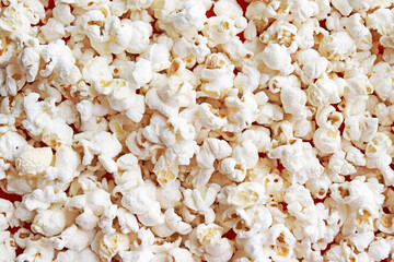 The texture of the popcorn. Scattered salted popcorn. Food background. Fast food popular while watching a movie at the cinema.