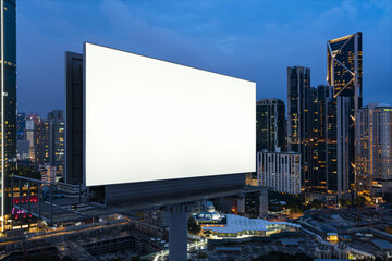 Blank white road billboard with KL cityscape background at night time. Street advertising poster, mock up, 3D rendering. Side view. The concept of marketing communication to promote or sell idea.