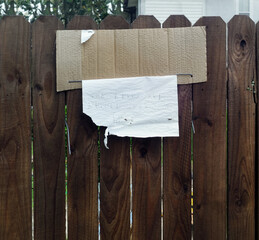 Wall Mural - Torn weathered note hanging from fence in ally.