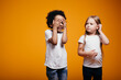 © DmitryStock - A boy and a girl of different nationalities in white t-shirts play hide and seek together. Children do not have racism