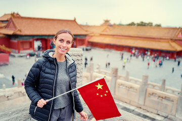 Wall Mural - Enjoying vacation in China. Traveling young woman with national chinese in Forbidden City, Beijing.