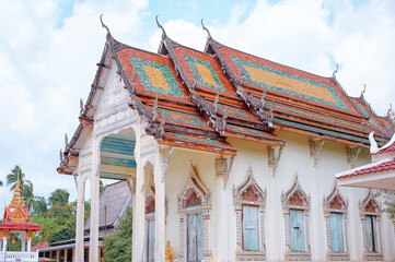 Canvas Print - White Buddhist temple with richly decorated windows and roof. Traditional religious art, architecture of Thailand.