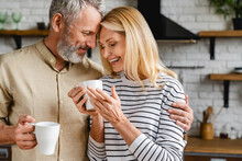 Affectionate mature couple bonding and enjoying cup of coffee