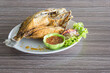 fried fish and seafood sauce on wood table background, Thai food.