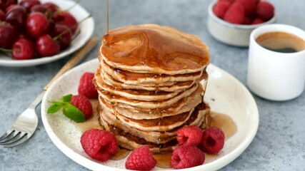 Wall Mural - Maple Syrup Pouring On Pancakes Served With Raspberries. Tasty Sweet Breakfast Food