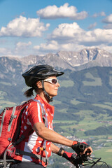 Wall Mural - pretty senior woman riding her electric mountain bike on the mountains above the Iller valley between Sonthofen and Oberstdorf, Allgau Alps, Bavaria Germany
