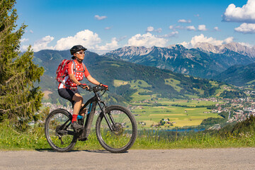 Wall Mural - pretty senior woman riding her electric mountain bike on the mountains above the Iller valley between Sonthofen and Oberstdorf, Allgau Alps, Bavaria Germany
