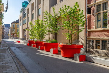 Wall Mural - Ghent street with trees in giant red pots, Belgium