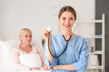 Canvas Print - Young female doctor with stethoscope in hospital room