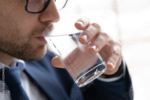 Cuadros en Lienzo Close up of thirsty caucasian male employee drink pure clean mineral water from