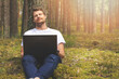 © ronstik - remote work in nature - man with laptop relaxing in the woods