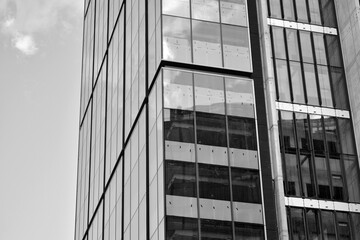 Urban geometry, looking up to glass building. Modern architecture, glass and steel. Abstract modern architecture design with high contrast black and white tone.