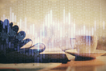 Double exposure of financial chart drawing and desktop with coffee and items on table background. Concept of forex market trading