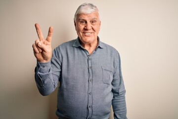 Wall Mural - Senior handsome hoary man wearing casual shirt standing over isolated white background showing and pointing up with fingers number two while smiling confident and happy.