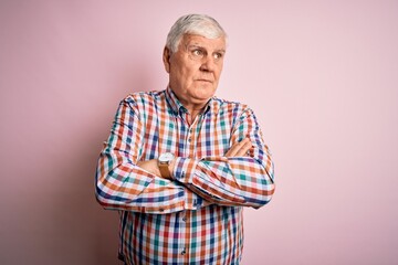 Senior handsome hoary man wearing casual colorful shirt over isolated pink background looking to the side with arms crossed convinced and confident