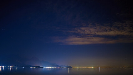 Night starry sky with sea and mountain views.
