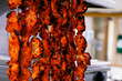 spice marinated chicken cubes ( chicken tikka )skewers cooking in a clay oven known as tandoor