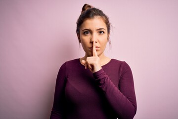 Sticker - Beautiful young woman wearing casual bun hairstyle over pink isolated background asking to be quiet with finger on lips. Silence and secret concept.