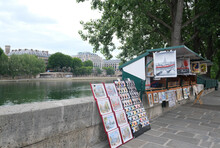 PARIS, FRANCE – JUNE 07, 2020: Old Booths Stalls Of Typical Parisian Booksellers Selling Second-hand And Antique And Souvenirs Along The River Seine Banks On A Cloudy Day