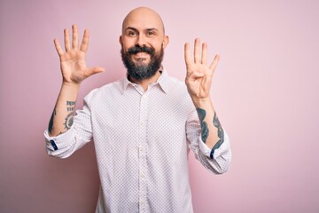 Poster - Handsome bald man with beard wearing elegant shirt over isolated pink background showing and pointing up with fingers number nine while smiling confident and happy.