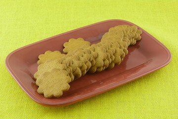 Wall Mural - Swedish thin ginger cookies on red party platter on yellow tablecloth