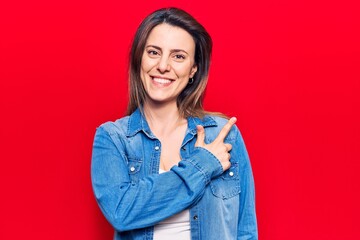 Young beautiful woman wearing casual clothes cheerful with a smile of face pointing with hand and finger up to the side with happy and natural expression on face