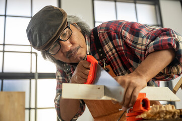 old carpenter man working from home with wood handmade, craft product wooden work production at home