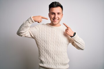 Wall Mural - Young handsome caucasian man wearing casual winter sweater over white isolated background smiling cheerful showing and pointing with fingers teeth and mouth. Dental health concept.