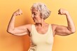 © Krakenimages.com - Senior grey-haired woman wearing casual clothes showing arms muscles smiling proud. fitness concept.